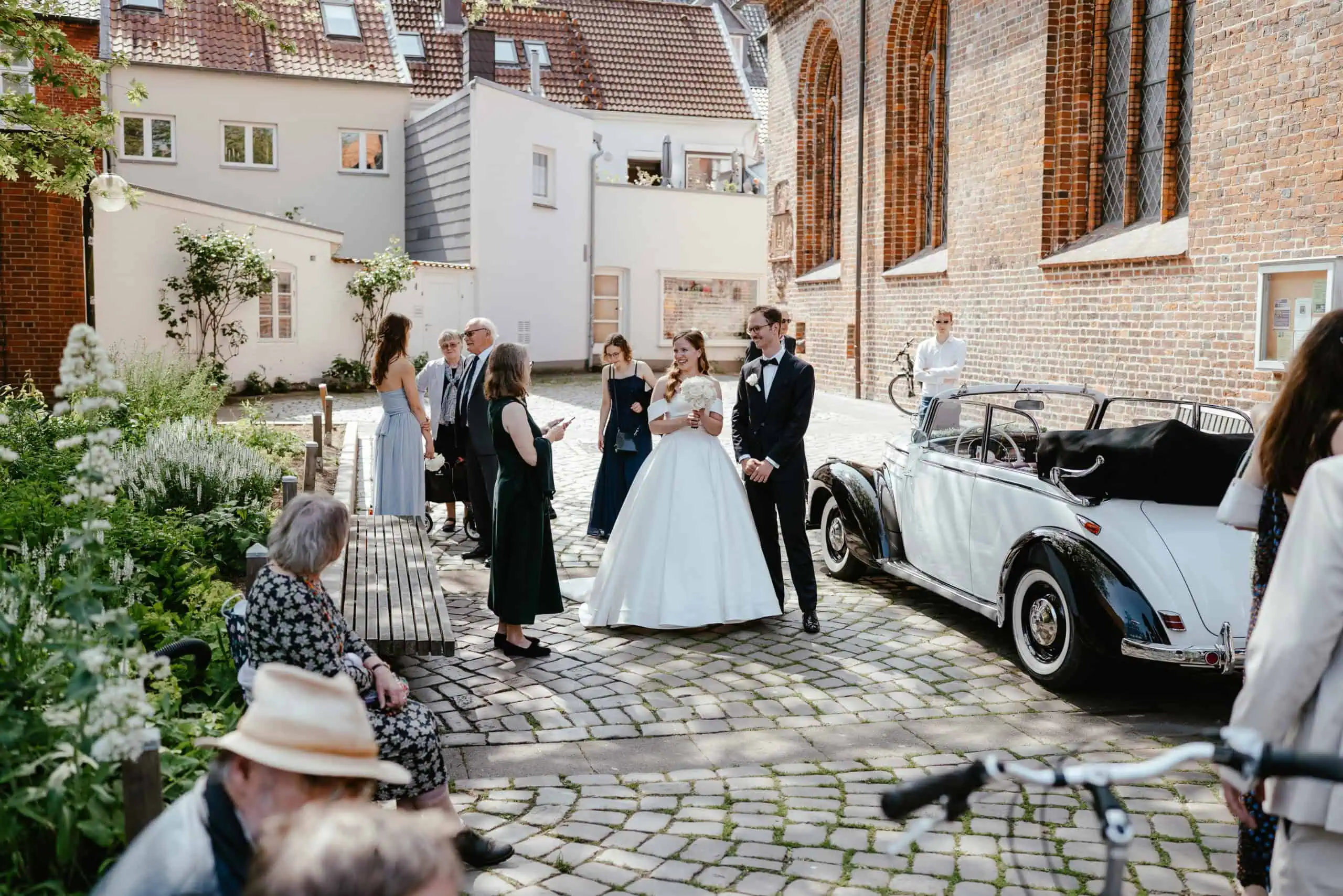 Paarfotografie: Ein Paar umarmt sich liebevoll und schaut sich dabei vertraut am Timmendorfer Strand an.